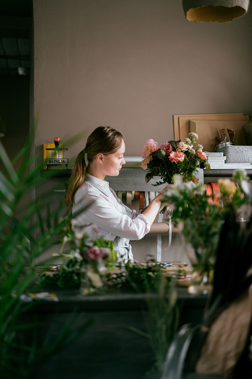 Woman with bouquet of flowers in floral shop